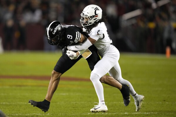 Iowa State wide receiver Jayden Higgins (9) is tackled by Cincinnati defensive back Kalen Carroll, right, after catching a pass during the first half of an NCAA college football game, Saturday, Nov. 16, 2024, in Ames, Iowa. (AP Photo/Charlie Neibergall)
