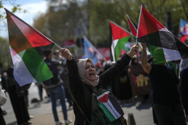 FILE - A woman waves flags in support of Palestinians in Gaza during a protest in Istanbul, Turkey, Friday, April 5, 2024. Turkey and Israel announced tit-for-tat trade barriers on Tuesday, April 9, 2024, as relations between them further deteriorated amid the war in Gaza. Turkey, a staunch critic of Israel’s military actions in Gaza, first announced that it was restricting exports of 54 types of products to Israel with immediate effect. The products include aluminum, steel, construction products, jet fuel and chemical fertilizers. Responding to the Turkish trade restrictions, Israel said it was preparing a ban on products from Turkey. (AP Photo/Khalil Hamra, File)