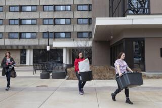 FILE - Calli Fiez, right, and her mother, Kim, carry her belongings to their car while moving out of Witte Residence Hall Thursday, March 12, 2020 on the campus of UW-Madison in Madison, Wis. A Republican state lawmaker plans to block the University of Wisconsin from instituting COVID-19 testing, masking and vaccination protocols on campuses across the state, a move that comes as health officials sound warnings about the rapidly spreading, highly contagious delta variant. (Mark Hoffman/Milwaukee Journal-Sentinel via AP, File)