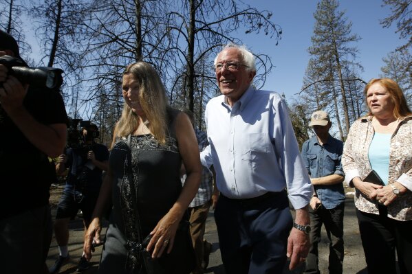 Democratic presidential candidate Sen. Bernie Sanders, I-Vermont, right, talks with area resident Susan Dobra, left, as he tours a mobile home park that was destroyed by last year's wildfire in Paradise, Calif., Thursday, Aug. 22, 2019.  Sanders released a $16.3 trillion climate plan Thursday that builds on the Green New Deal and calls for the United States to move to renewable energy across the economy by 2050 and declare climate change a national emergency.
 (AP Photo/Rich Pedroncelli)