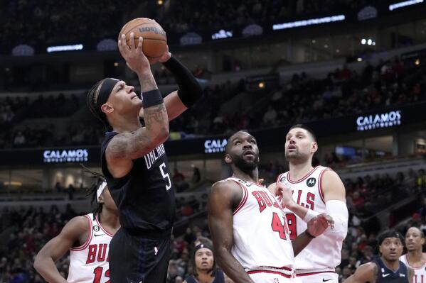 Orlando Magic's Paolo Banchero (5) shoots as Chicago Bulls' Patrick Williams (44) and Nikola Vucevic watch during the first half of an NBA basketball game Monday, Feb. 13, 2023, in Chicago. (AP Photo/Charles Rex Arbogast)