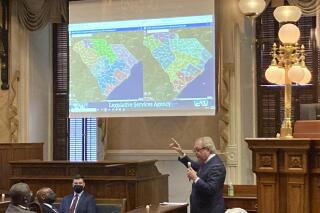State Sen. Dick Harpootlian, D-Columbia, compares his proposed map of U.S. House districts drawn with 2020 U.S. Census data to a plan supported by Republicans on Thursday, Jan. 20, 2022, in Columbia, S.C.. The full Senate was debating the maps. (AP Photo/Jeffrey Collins)