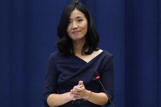 Michelle Wu pauses while acknowledging a standing ovation after she was sworn-in as Boston Mayor during a ceremony at Boston City Hall, Tuesday, Nov. 16, 2021, in Boston. The election of Wu marked the first time that Boston voters elected a woman, or a person of color, to lead the city. (AP Photo/Charles Krupa)