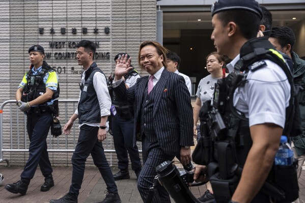 Lawrence Lau, a former pro-democracy district councilor, waves hand to media as he leaves the West Kowloon Magistrates' Courts in Hong Kong, Thursday, May 30, 2024. Fourteen pro-democracy activists were convicted in Hong Kong’s biggest national security case on Thursday by a court that said their plan to effect change through an unofficial primary election would have undermined the government’s authority and created a constitutional crisis.(AP Photo/Chan Long Hei)