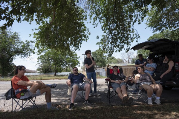 Project ICECHIP members, from left, Ethan Mok, Logan Bundy, Nathan Sonntag, Victor Gensini and Katie Wargowsky sit in chairs next to the command vehicle waiting for storms to develop Friday, June 6, 2025, in Morton, Texas. (AP Photo/Carolyn Kaster)