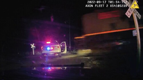 This screen grab from dash camera video provided by the Fort Lupton Police Department shows a freight train barreling toward a parked police car with a suspect inside, Sept. 16, 2022, in Fort Lupton, Colo. A trial began Monday, July 24, 2023, for the police officer accused of putting the handcuffed woman in the car that was hit by the train. The collision seriously injured 21-year-old Yareni Rios. The date/time stamp shown on the video is incorrect. (Fort Lupton Police Department via AP)