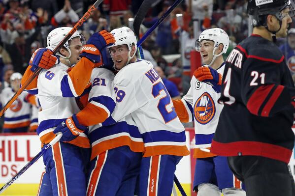 The New York Islanders celebrate a goal by Kyle Palmieri during the third period of an NHL hockey game against the Carolina Hurricanes in Raleigh, N.C., Friday, April 8, 2022. (AP Photo/Karl B DeBlaker)