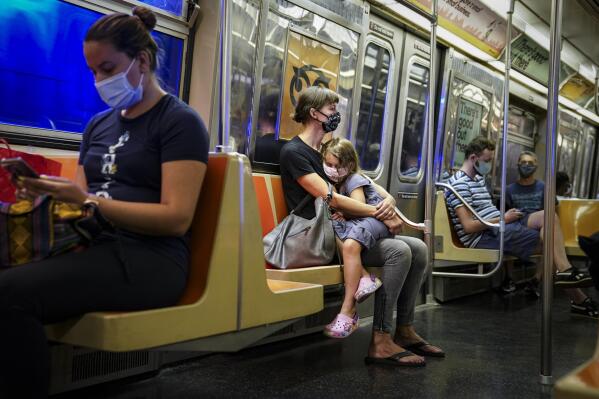 FILE - This photo from Monday, Aug. 17, 2020, shows riders on a subway train wearing protective masks due to COVID-19 concerns in New York. The Metropolitan Transportation Authority on Friday launched a campaign that has celebrities including Jerry Seinfeld, Whoopi Goldberg, and Awkwafina making the announcements heard at subway stations, on trains, and buses. (AP Photo/John Minchillo, File)