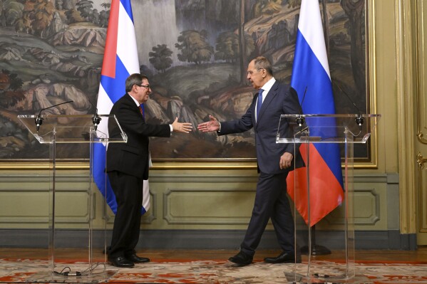 Russian Foreign Minister Sergey Lavrov, right, and his Cuban counterpart Bruno Eduardo Rodríguez Parrilla shake hands after a joint news conference following their talks in Moscow, Russia, Wednesday, June 12, 2024. (Natalia Kolesnikova/Pool Photo via AP)