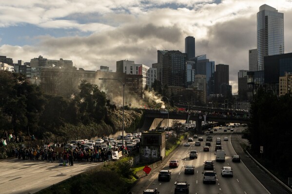 Protesters calling for a cease-fire in the Israel-Hamas war block Interstate 5 northbound, Saturday, Jan. 6, 2024 in downtown Seattle. (AP Photo/Lindsey Wasson)