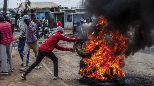 Een demonstrant verbrandt banden om een ​​weg te blokkeren in de wijk Kibera in Nairobi, Kenia, woensdag 12 juli 2023. Antiregeringsdemonstranten demonstreren in een aantal Keniaanse steden tegen nieuw ingevoerde belastingen en de kosten van levensonderhoud.  (AP Foto/Samson Otieno)
