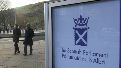 FILE - People walk past the Scottish Parliament in Edinburgh, on March 16, 2014. The Scottish government has proposed decriminalizing possession of all drugs for personal use to tackle one of Europe’s highest overdose death rates. The semi-autonomous Edinburgh government, led by the pro-independence Scottish National Party, said Friday, July 7, 2023, that removing criminal penalties for drug possession would “allow for the provision of safe, evidence-based harm reduction services.” (AP Photo/Jill Lawless, File)