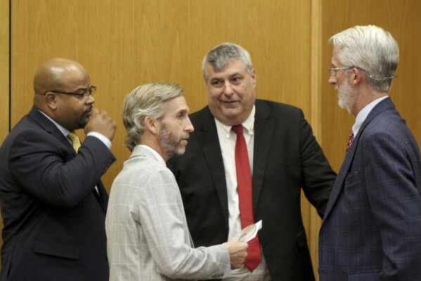 District Investigator Damian Gatlin, left, attorney Dan Kitchens, second from left, Lincoln County District Attorney Dee Bates, second from right and attorney Mike Kitchens confer over evidence at the trial of two white men who are accused of chasing and shooting at a Black FedEx driver who had dropped off a package at a home, Wednesday, Aug. 16, 2023, in Brookhaven, Miss. (Hunter Cloud/The Daily Leader via AP)