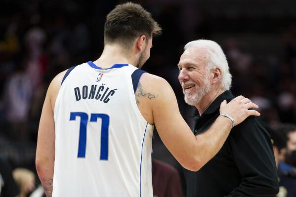 Dallas Mavericks guard Luka Doncic (77) and San Antonio Spurs coach Gregg Popovich talk after an NBA basketball game, Thursday, Oct. 28, 2021, in Dallas. Dallas won 104-99. (AP Photo/Sam Hodde)