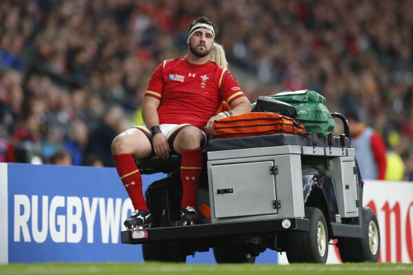 FILE - Wales' Scott Baldwin is taken off the pitch during the Rugby World Cup quarterfinal match between South Africa and Wales at Twickenham Stadium, London, Saturday, Oct. 17, 2015. Scotland forward Dave Cherry is out of the Rugby World Cup in France after slipping on the stairs at the team hotel, banging his head and sustaining a concussion. He isn’t the first rugby player to get hurt in a strange way on his time off. Some of rugby’s tough men have come unstruck grappling with dogs, dishwashers and even an out-of-control fire. (AP Photo/Frank Augstein, File)