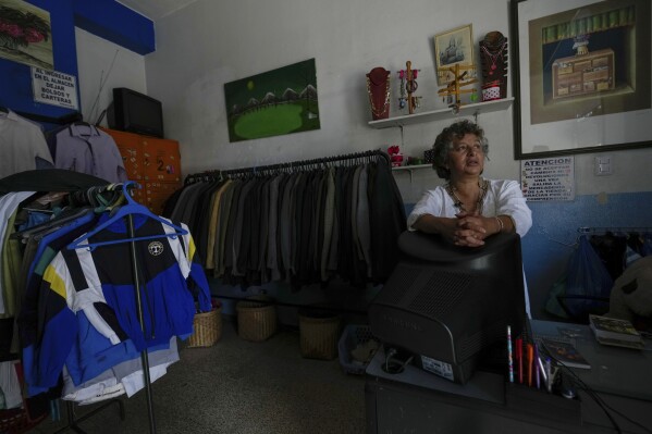 A seller waits for customers despite not having electricity due to a programed power cut by the ministry of energy, in Quito, Ecuador, Tuesday, April 16, 2024. Ecuador faces electricity rationing due to a prolonged drought and high temperatures that have reduced flows to the main hydroelectric plants. (AP Photo/Dolores Ochoa)