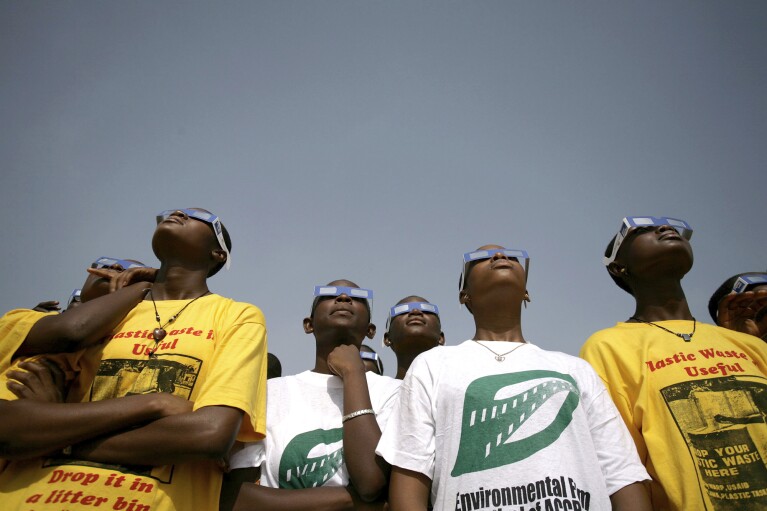 FILE - A group of school children look at the solar eclipse in Accra, Ghana, Wednesday, March 29, 2006, which swept from Brazil to Mongolia. (AP Photo/Olivier Asselin, File)