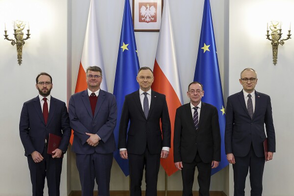 FILE - In this photo provided by the Poland's Presidential Palace, Poland's President Andrzej Duda, center, poses with new adviser Stanislaw Zaryn, far left, former deputy interior minister Maciej Wasik, and to his right former interior minister Mariusz Kaminski, and new adviser Blazej Pobozy in Warsaw, Poland, Tuesday, Jan. 9, 2024. Poland’s president said Tuesday, Jan. 23, 2024, he was once again pardoning two politicians who were arrested earlier this month amid a bitter standoff between the new centrist government and the previous conservative administration. (Jakub Szymczuk/Poland's Presidential Palace via AP, File)
