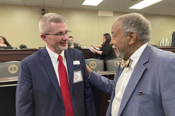 Robbie Fletcher, left, chats with Kentucky state Sen. Gerald Neal after Fletcher spoke to a Senate committee on Friday, April 12, 2024, in Frankfort, Ky. Fletcher won state Senate confirmation on Monday, April 15, 2024, to become Kentucky's next education commissioner. (AP Photo/Bruce Schreiner)
