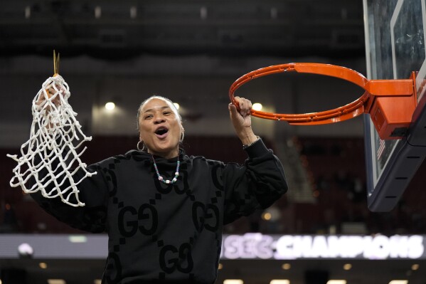 South Carolina head coach Dawn Staley celebrates cutting the net after their win against LSU in an NCAA college basketball game at the Southeastern Conference women's tournament final Sunday, March 10, 2024, in Greenville, S.C. (AP Photo/Chris Carlson)