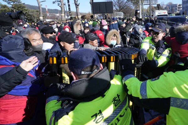 Dog farmers struggle with police officers during a rally against the government-led dog meat banning bill in front of the presidential office in Seoul, South Korea, Thursday, Nov. 30, 2023. (AP Photo/Ahn Young-joon)