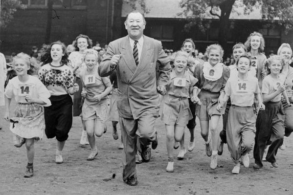 FILE - Big Jim Thorpe, famed American athlete and former U.S. Olympic great, center, sets a fast pace for some girls during a "junior olympics" event on Chicago's south side June 6, 1948 sponsored by a V.F.W. post. Jim Thorpe has been reinstated as the sole winner of the 1912 Olympic pentathlon and decathlon — nearly 110 years after being stripped of those gold medals for violations of strict amateurism rules of the time. The International Olympic Committee confirmed that an announcement was planned later Friday, July 15, 2022. (AP Photo, File)
