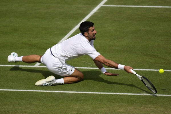 Serbia's Novak Djokovic falls as he returns to Spain's Carlos Alcaraz in the final of the men's singles on day fourteen of the Wimbledon tennis championships in London, Sunday, July 16, 2023. (AP Photo/Alastair Grant)