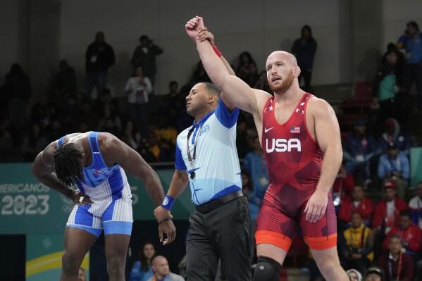 United States' Kyle Snyder, right, celebrates after winning gold against Cuba's Arturo Silot, left, during the men's 97kg wrestling freestyle final bout at the Pan American Games Santiago, Chile, Nov. 1, 2023. (AP Photo/Matias Delacroix, File)