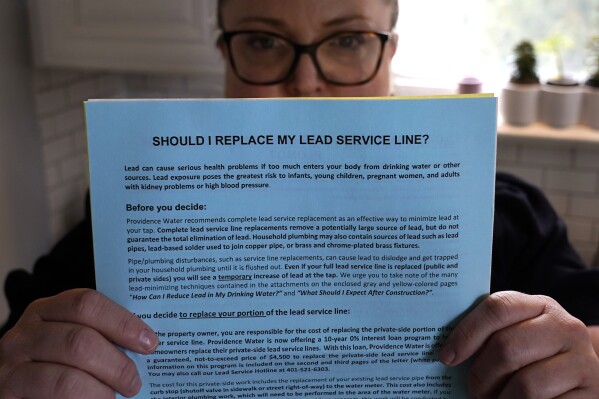 Colleen Colarusso, shows a letter she received from Providence Water citing health concerns with her residential water delivered through lead pipes, in the kitchen of her home, Thursday, March 23, 2023, in Providence, R.I. Testing showed lead levels in her water at more than twice the federal limit. Before that, she drank and cooked with tap water. (AP Photo/Charles Krupa)