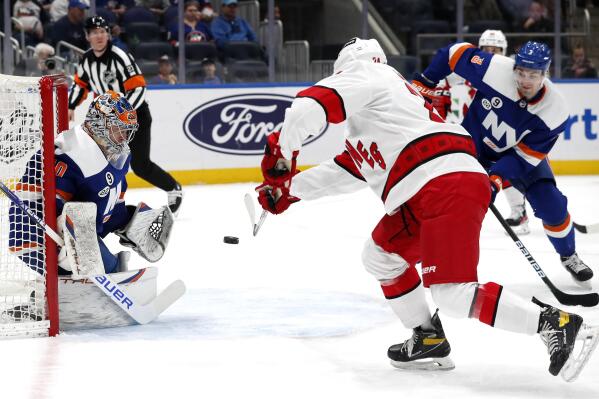 Carolina Hurricanes center Seth Jarvis (24) scores a goal against New York Islanders goaltender Semyon Varlamov (40) during the first period of an NHL hockey game, Sunday, April 24, 2022, in New York. (AP Photo/Noah K. Murray)