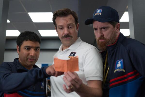 This image released by Apple TV Plus shows Nick Mohammed, from left, Jason Sudeikis, and Brendan Hunt in "Ted Lasso." The program was nominated for an Emmy Award for outstanding comedy series. Sudeikis was also nominated for outstanding lead actor in a comedy series and both Mohammed and Hunt were nominated for supporting actor in a comedy series. (Apple TV Plus via AP)