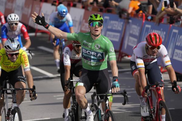 Sam Bennett of Ireland, wearing the best sprinter's green jersey, celebrates as he crosses the finish line ahead of Denmark's Mads Pedersen, right, to win the third stage of the Vuelta cycling race over 193.2 kilometers (120 miles) with start and finish in Breda, Netherlands, Sunday, Aug. 21, 2022. (AP Photo/Peter Dejong)
