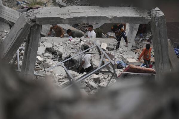 Palestinians inspect the damage caused by an Israeli army airstrike in Khan Younis, Gaza Strip, Tuesday, April 22, 2025. (AP Photo/Abdel Kareem Hana)