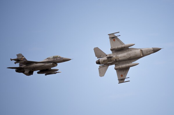 Romanian air force F-16 fighter planes fly above the Baza 86 military air base, outside Fetesti, Romania, Monday, Nov. 13, 2023. NATO member Romania inaugurated an international training hub for F-16 jet pilots from allied countries and other partners, including Ukraine, with airplanes supplied by the Royal Netherlands Air Force, and instructors and maintenance provided by Lockheed Martin, the aircraft maker. (AP Photo/Vadim Ghirda)