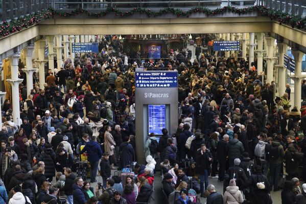 Passengers wait on the concourse at the entrance to the Eurostar in St Pancras International station, central London, Saturday Dec. 30, 2023, after high-speed services between London and Ebbsfleet were cancelled because of flooding in a tunnel under the Thames. (James Manning/PA via AP)