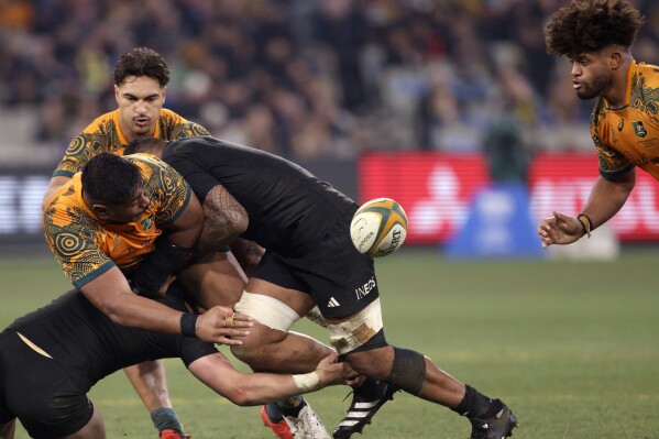 Australia's Will Skelton, left, unloads to Rob Valetini, right, as New Zealand's Jordie Barrett, left, makes the tackle during their Bledisloe Cup rugby union test match in Melbourne, Australia, Saturday, July 29, 2023. (AP Photo/Hamish Blair)