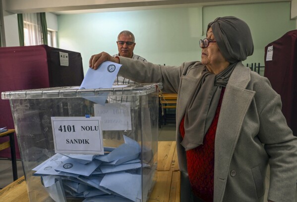 A woman votes at a polling station in Ankara, Sunday, March 31, 2024. Turkey holds local elections on Sunday that will decide who will control Istanbul and other major cities.  (AP Photo/Ali Onal)