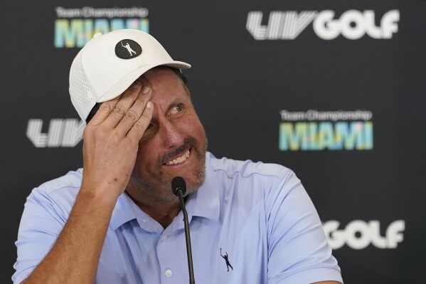 FILE - Phil Mickelson reacts during a news conference for the LIV Golf Team Championship at Trump National Doral Golf Club, Wednesday, Oct. 26, 2022, in Doral, Fla. At the dawn of 2023, the specter of Saudi Arabia’s growing influence on pro golf — and sports in general — served not only as a moral conundrum for players and their fans, but also, some argued, as an existential threat to the multibillion-dollar professional-sports industry itself. Twelve months later, it's a different conversation, now virtually devoid of concern about supposed “sportswashing” and more fixed on just how rich the Saudis might make all these athletes before they’re done investing. (AP Photo/Lynne Sladky, File)