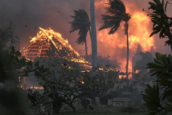 FILE - The hall of historic Waiola Church in Lahaina and nearby Lahaina Hongwanji Mission are engulfed in flames along Wainee Street on Aug. 8, 2023, in Lahaina, Hawaii. Communities still reeling from climate-fueled storms and other natural disasters, from the wildfires in Maui to severe flooding in New England, fear a federal government shutdown will delay needed disaster relief.(Matthew Thayer/The Maui News via AP, File)