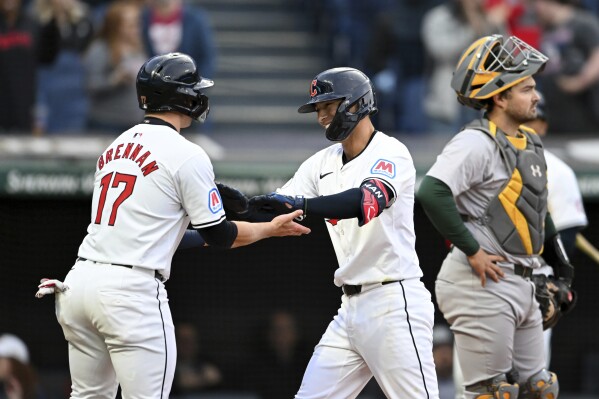 Cleveland Guardians' Will Brennan (17) and Tyler Freeman celebrate Freeman's two-run home run off Oakland Athletics starting pitcher Joe Boyle during the second inning of a baseball game Friday, April 19, 2024, in Cleveland. (AP Photo/Nick Cammett)