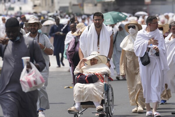 Pilgrims leave after offering prayers outside at the Grand Mosque, during the annual Hajj pilgrimage in Mecca, Saudi Arabia, Thursday, June 13, 2024. Hajj is the annual Islamic pilgrimage to Mecca in Saudi Arabia that is required once in a lifetime of every Muslim who can afford it and is physically able to make it. Some Muslims make the journey more than once. (AP Photo/Rafiq Maqbool)