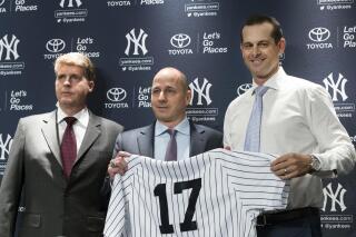 FILE - New York Yankees owner Hal Steinbrenner, left, general manager Brian Cashman, center, and Aaron Boone, pose for photographers during a news conference introducing Boone as the baseball team's new manager on Dec. 6, 2017, at Yankee stadium in New York. Steinbrenner praised general manager Brian Cashman and manager Aaron Boone on Wednesday, Nov. 17, 2021, and said he is open to a new contract for slugger Aaron Judge. (AP Photo/Mary Altaffer, File)