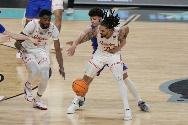 Florida's Walter Clayton Jr., rear, knocks the ball away from Houston's Emanuel Sharp (21) during the second half in the national championship at the Final Four of the NCAA college basketball tournament, Monday, April 7, 2025, in San Antonio. (AP Photo/Stephanie Scarbrough)