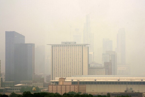 The Marriott Marquis, left, and the Hyatt Regency McCormick Place, center, stand above The McCormick Place Convention Center in a veil of haze from Canadian wildfires obscuring the majestic Chicago skyline, as seen from the city's Bronzeville neighborhood Tuesday, June 27, 2023, in Chicago. (AP Photo/Charles Rex Arbogast)