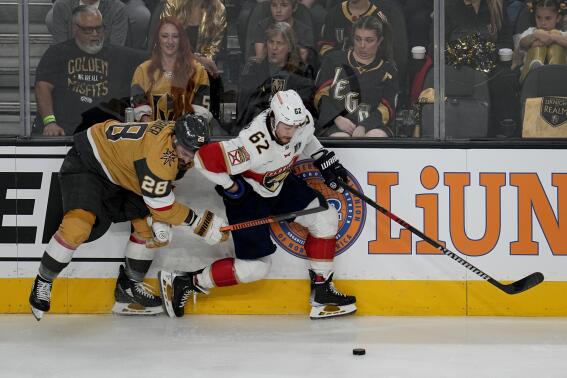 Vegas Golden Knights left wing William Carrier (28) battles Florida Panthers defenseman Brandon Montour (62) for control during the first period of Game 1 of the NHL hockey Stanley Cup Finals, Saturday, June 3, 2023, in Las Vegas. (AP Photo/Abbie Parr)