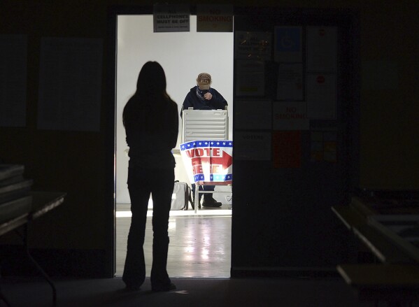 FILE - A first-time voter waits in the doorway for a voting booth as another voter completes his ballot at the Boot City Opry near Terre Haute, Ind., Nov. 3, 2020. (Joseph C. Garza/The Tribune-Star via AP, File)