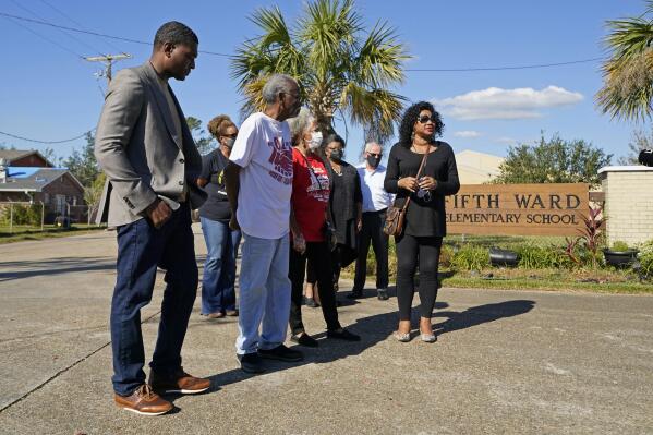 FILE - EPA Administrator Michael Regan, left, arrives at the Fifth Ward Elementary School, which is near the Denka plant, with Robert Taylor, second left, founder of Concerned Citizens of St. John's Parish, and Lydia Gerard, third left, a member of the group, in Reserve, La., Nov. 16, 2021. In what could prove a significant move for communities facing air pollution, the Environmental Protection Agency proposed on Thursday, April 6, 2023, that chemical plants nationwide measure certain hazardous compounds that cross beyond their property lines and reduce them when they are too high. (AP Photo/Gerald Herbert, File)