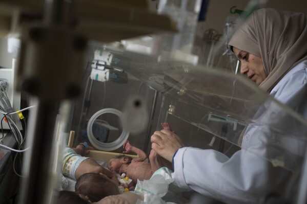 A nurse prepares premature babies for transport to Egypt after they were evacuated from Shifa Hospital in Gaza City to a hospital in Rafah, Gaza Strip, Monday, Nov. 20, 2023. (AP Photo/Fatima Shbair)