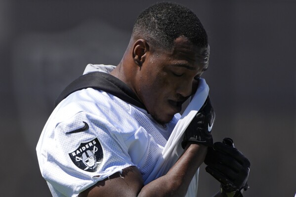 Las Vegas Raiders running back Zamir White wipes sweat from his face during an NFL football practice Tuesday, June 4, 2024, in Henderson, Nev. (AP Photo/John Locher)