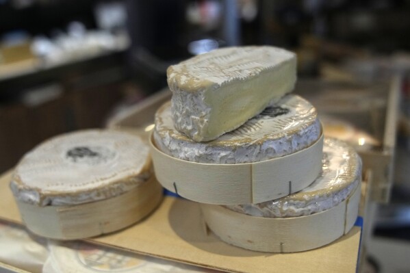 Camembert cheeses in their box are on sale in a Ville d'Avray cheese shop, outside Paris, Tuesday, Nov. 21, 2023. In one of the many legal proposals on streamlining and optimizing waste management throughout the 27-nation bloc, some French cheese producers sniffed out something and turned it into a culinary stink. They claimed that the proposal would make it illegal for Camembert to be cradled into the wooden packaging for its final weeks of ripening and, eventually, sale. The round box is as essentially Camembert as its unctuous texture and pungent smell(AP Photo/Christophe Ena)